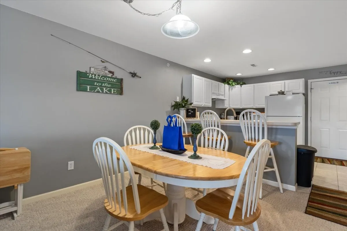 A dining area with a welcoming table, a 'welcome' sign, and a kitchen area in the background. The setting is intimate and inviting, perfect for sharing meals or gathering for game nights after a day out.